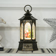 Swirling-Christmas-Santa-Snow-Globe-Lantern-with-Music-and-Lights,-Battery-Operated--Bronze-Christmas-Decor