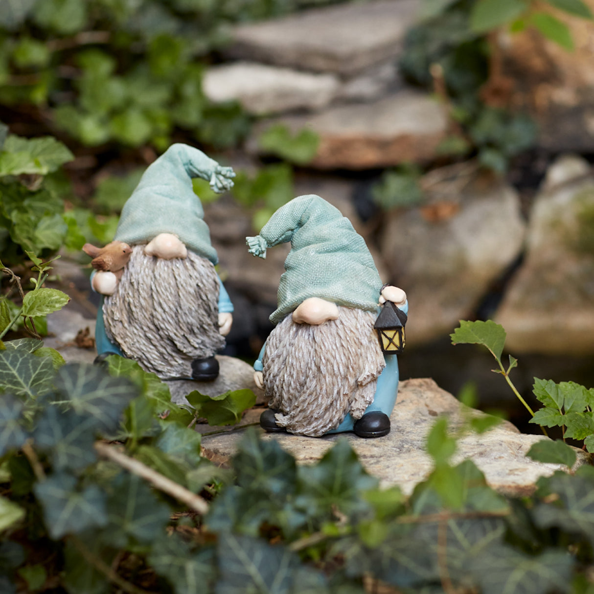 Stone garden gnome figurine with bird and lantern accent (set of 4)