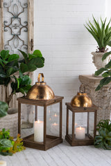 Set-of-2-Brown-Wooden-Lanterns-with-Clear-Glass-Panels-and-Gold-Metal-Dome-Accents,-L:14x14x28.5'--S:11x11x23'-Lanterns