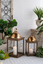 Set-of-2-Brown-Wooden-Lanterns-with-Clear-Glass-Panels-and-Gold-Metal-Dome-Accents,-L:14x14x28.5'--S:11x11x23'-Lanterns